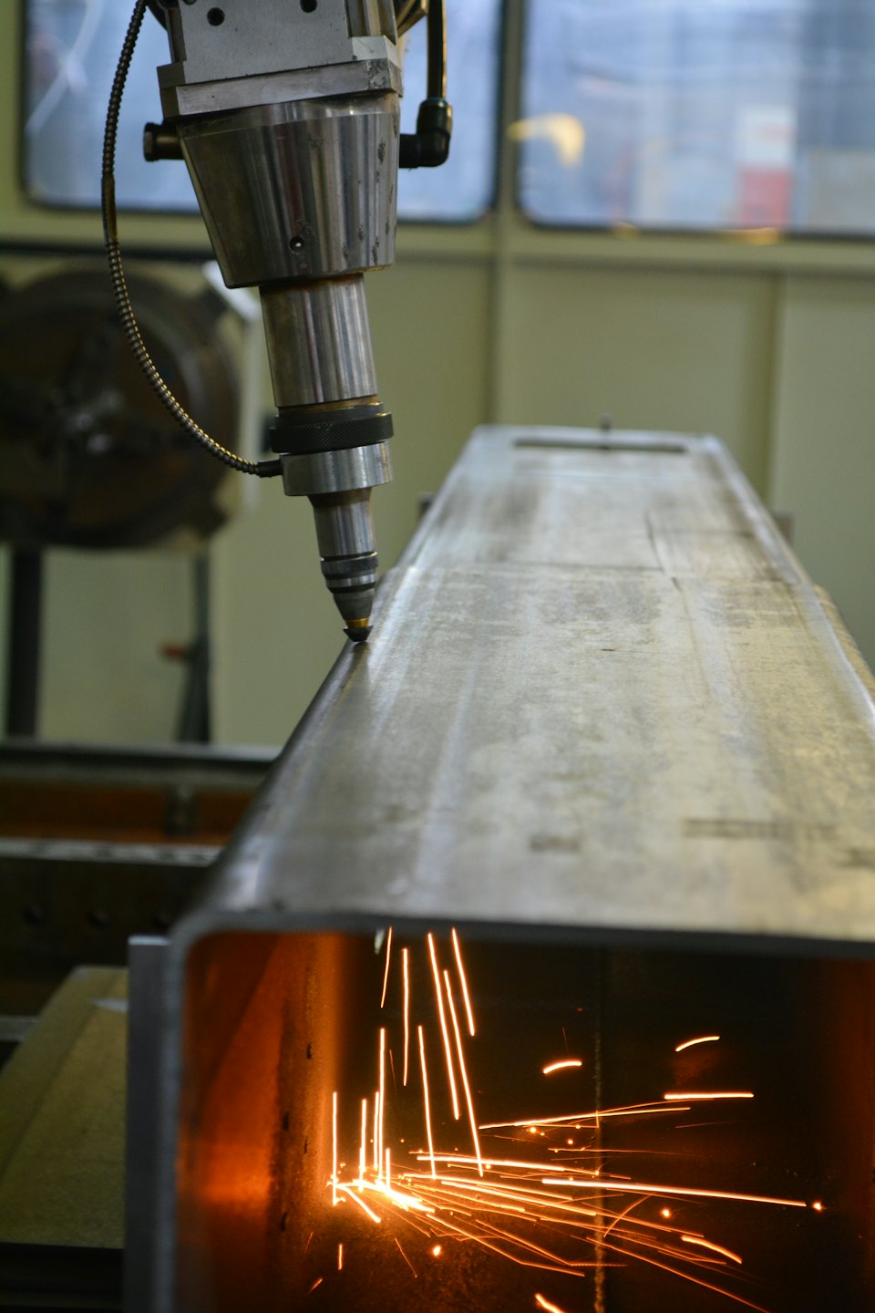 Vonken vliegen als een laser door een metalen balk snijdt.