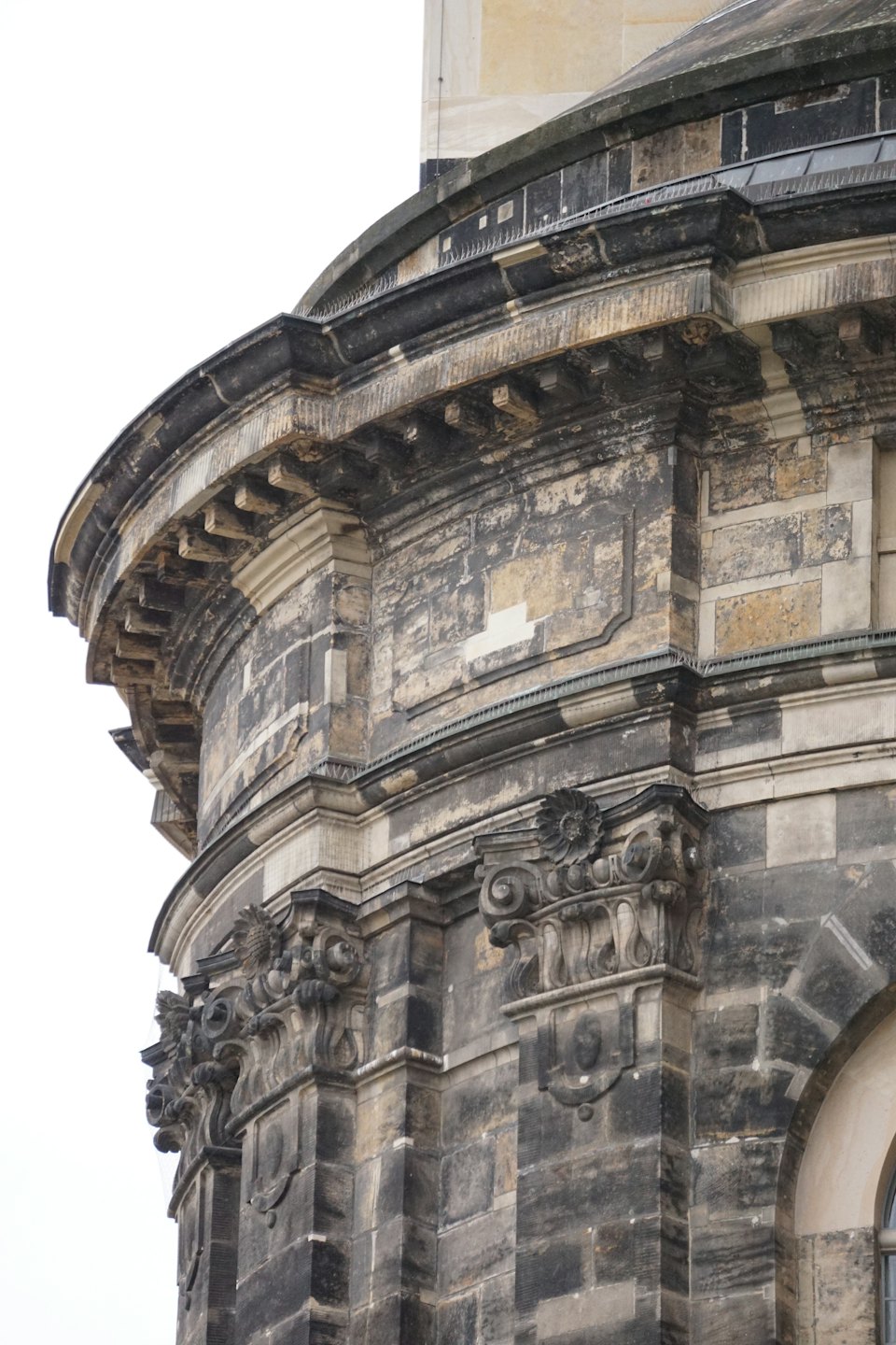 Sierlijke steenhouwwerken sieren de gevel van een historisch gebouw.